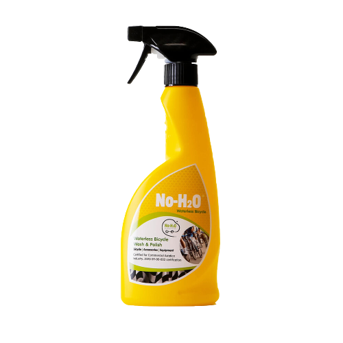 A "No-H2O" waterless bicycle wash & polish spray bottle. The product is designed for cleaning bicycles without the need for water. The bottle is yellow with a spray nozzle. The label emphasises its waterless cleaning properties and mentions its suitability for bicycles specifically.